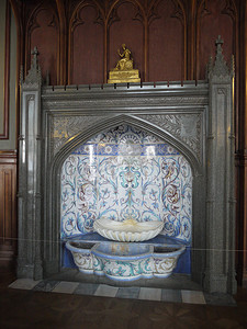 装饰品摄影照片_一座古老的喷泉，上面有五颜六色的装饰品和金色的小雕像