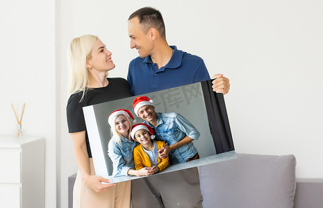 一家人拿着带圣诞图片的照片画布