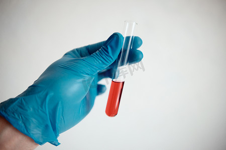 一种带有红色试剂的玻璃管，一种药物分析，手持在白色背景中