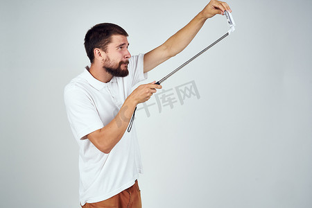 穿白色 T 恤的男人自拍杆趣味科技照片