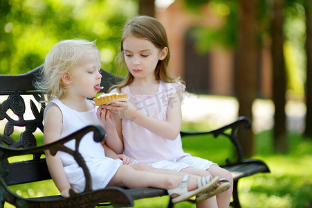 两个小姐妹分享美味的奶油馅饼