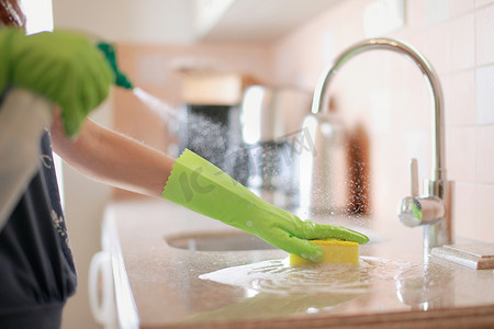 妇女用喷雾洗涤剂、家政和卫生概念清洁和抛光厨房台面