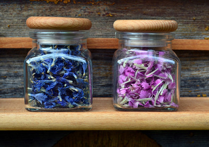 粉色花朵小花朵摄影照片_透明罐子里的粉色和蓝色花朵