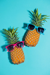 蓝色背景中戴着太阳镜的滑稽菠萝
