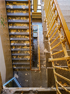 废弃楼梯摄影照片_旧废弃医院带金属栏杆的肮脏混凝土楼梯