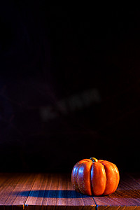 万圣节概念 — 橙色南瓜灯笼放在黑色背景的深色木桌上，不给糖就捣蛋，特写