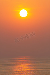 日落时分，海面反射着橙色的阳光。