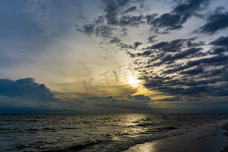 日照阳光海岸摄影照片_傍晚的天空乌云密布，阳光反射海水，海面