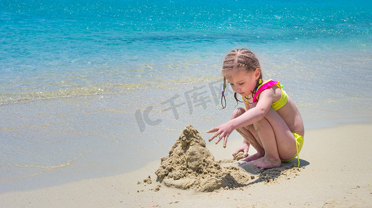 在沙滩上玩沙子的小女孩