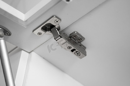 平开门强化摄影照片_镀铬橱柜平开门铰链，内置衣柜、橱柜或厨房的家具配件硬件。