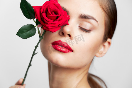 长着闭着眼睛的女人拿着玫瑰脸发型清爽的皮肤
