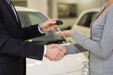 商人在与顾客握手时给车钥匙