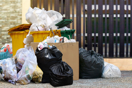 许多垃圾箱回收和垃圾塑料袋在栅栏家，许多垃圾塑料袋前屋，污染垃圾，大量垃圾场，塑料垃圾是环境污染