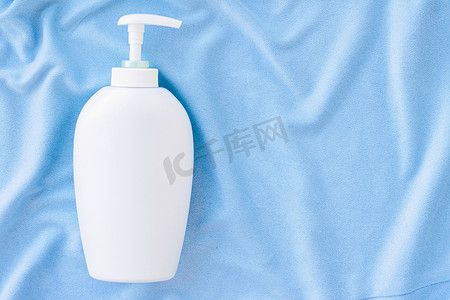 蓝色丝绸、卫生用品和保健品上抗菌液体肥皂和洗手液模型的空白标签瓶