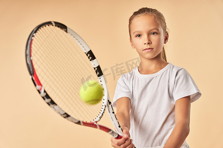 打网球的白色衬衣的可爱的女孩