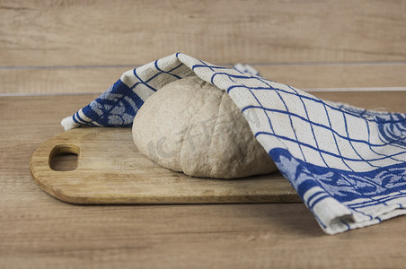 面团发酵摄影照片_在木质表面上发酵或发酵的面包或比萨面团