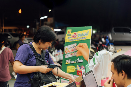 手机二维码扫描摄影照片_亚洲女性在百货商店用手机扫描二维码