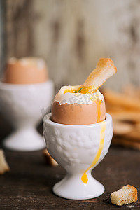 熟蛋黄摄影照片_蛋黄从吐司上的煮鸡蛋流出