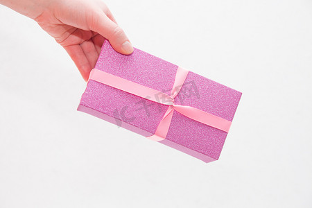 浅白色背景上的粉色闪亮礼盒，带粉色圆点弓顶视图