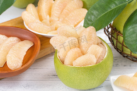 深海蜜柚摄影照片_新鲜去皮的柚子、柚子、葡萄柚、柚子在明亮的木桌背景上。