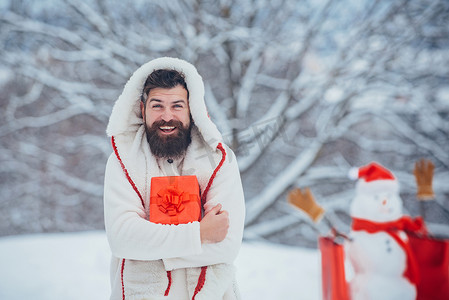雪人海报背景摄影照片_穿着圣诞礼物的男人在圣诞节背景附近。