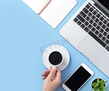 自由职业者博客作家女性在干净的浅蓝色桌子上喝咖啡放松，在家工作概念，复制空间，平躺，顶视图，模型