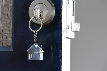 用钥匙和家居形状的钥匙扣打开新家的大门。