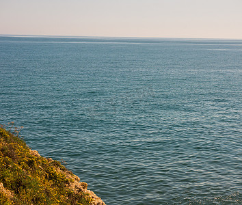 企业海面摄影照片_海面上的高崖，夏季海背景，许多飞溅的波浪和石头
