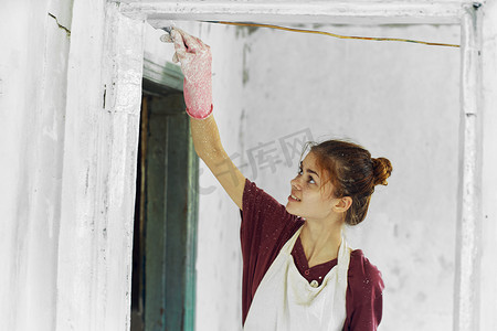 开朗的女画家在白色围裙的家庭装修中