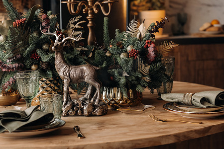 圣诞节鹿摄影照片_圣诞餐桌装饰、上菜前戴眼镜的宴会桌、带季节性装饰的圣诞餐桌特写、水晶玻璃和装饰鹿