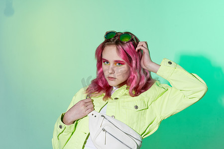 孟菲斯粉色摄影照片_开朗的女人绿色夹克时髦的衣服孤立的背景