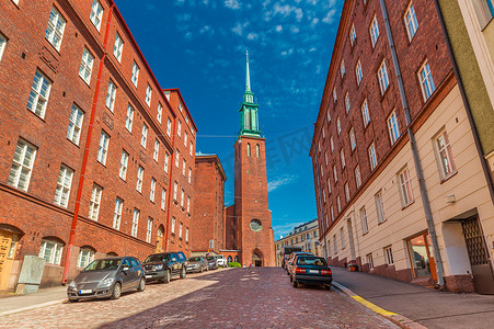 砖红色摄影照片_赫尔辛基的一条街道，拥有传统建筑和芬兰新哥特式风格的教堂 (Kristuskyrkan)