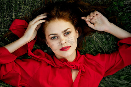 穿红裙子的女人躺在草地上致辞时尚夏日