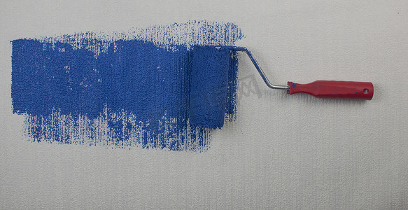 滚筒刷涂漆，工人在表面墙面涂漆公寓上涂漆，用深蓝色油漆翻新。