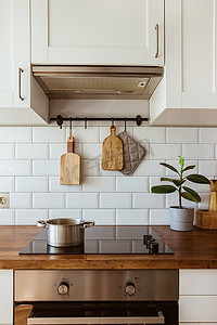 在现代白色厨房的电磁炉上用锅煮水和锅