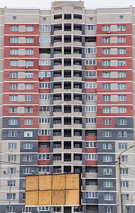 红色崛起摄影照片_住宅高层多色建筑由红色、灰色和白色砖块制成。
