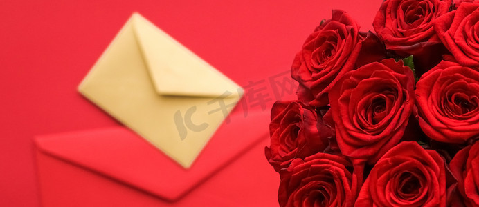 艺术传达摄影照片_情人节情书和鲜花递送服务、豪华红玫瑰花束和红色背景的卡片信封