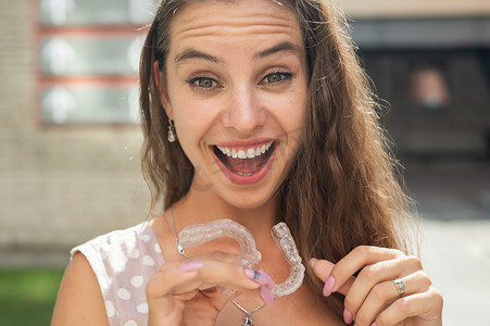 美丽的白种女人拿着透明护牙套进行咬合矫正。