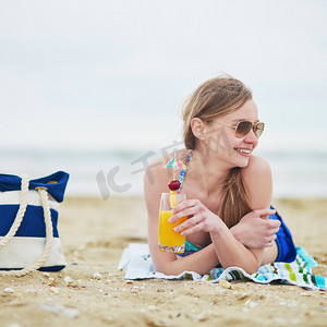 晒水摄影照片_在海滩上放松和晒日光浴的女人