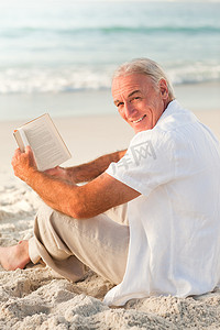 在海滩上看书的男人