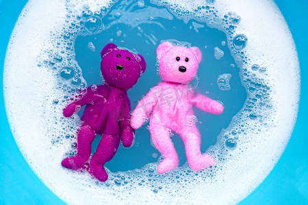 将小熊玩具浸泡在洗衣粉水中溶解后