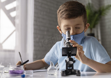 中景孩子通过显微镜看。