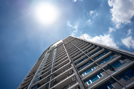 阳光洒满摄影照片_摩天大楼的玻璃幕墙在阳光明媚的日子里，蓝天上洒满阳光。