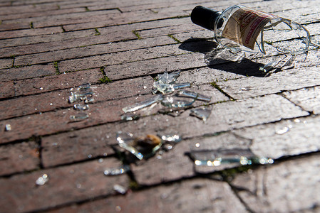 砖路上破碎的玻璃悲伤酒瓶。