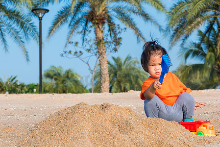 快乐的女儿女孩有趣地挖掘玩沙子玩具