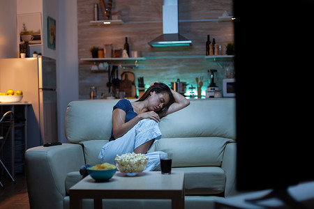 睡觉做梦摄影照片_睡在电视机前沙发上的女人