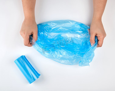 手中的蓝色塑料垃圾袋