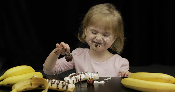 孩子吃草莓加融化的巧克力和生奶油