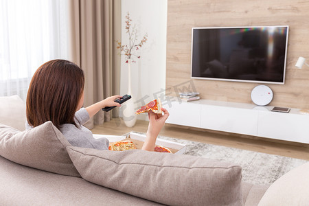 披萨diy摄影照片_单身女人吃披萨看电视