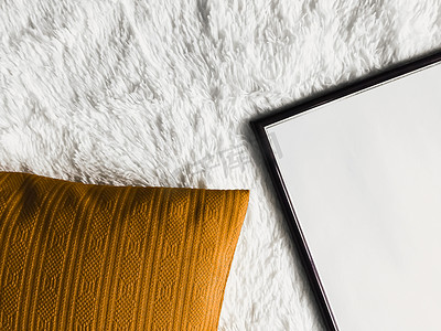 黑色薄木框架，空白复制空间作为海报照片打印模型、金色坐垫枕头和蓬松的白色毯子、平躺背景和艺术产品